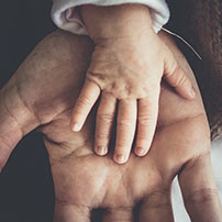 Mano de Beb sobre mano de Padre